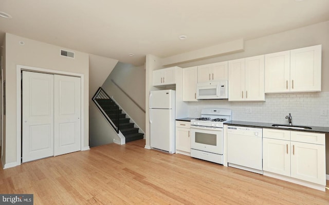 kitchen with white cabinetry, decorative backsplash, white appliances, light wood-type flooring, and sink