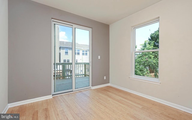 empty room featuring a healthy amount of sunlight and light hardwood / wood-style floors