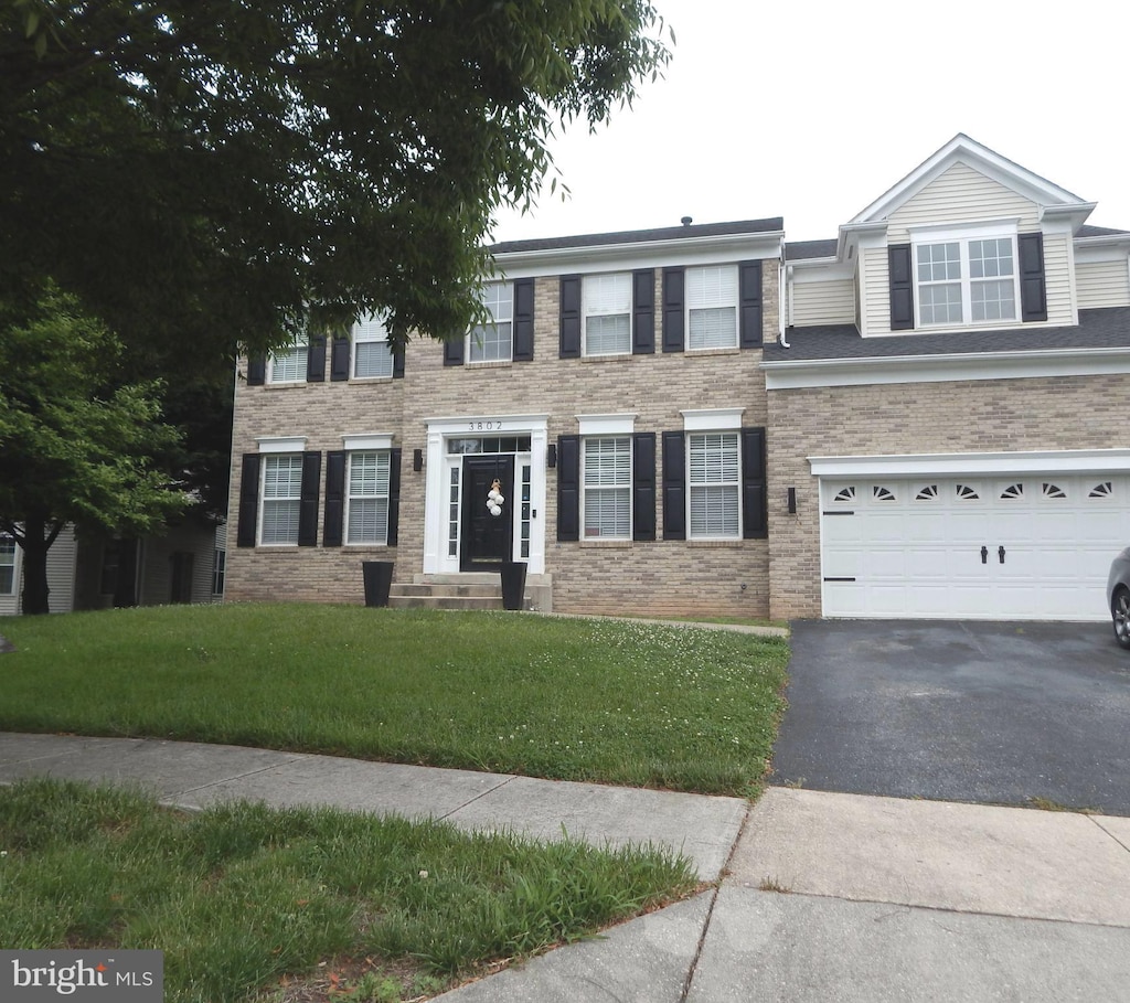 view of front of property featuring a garage and a front lawn