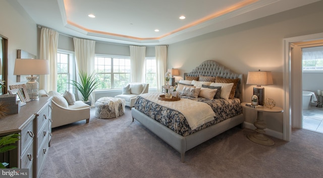 bedroom with a tray ceiling and dark colored carpet