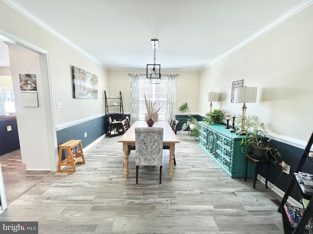 dining area featuring ornamental molding and light wood-type flooring