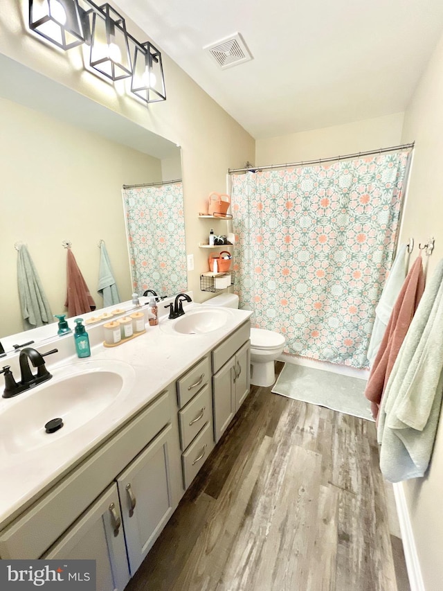 bathroom with vanity, hardwood / wood-style flooring, toilet, and walk in shower