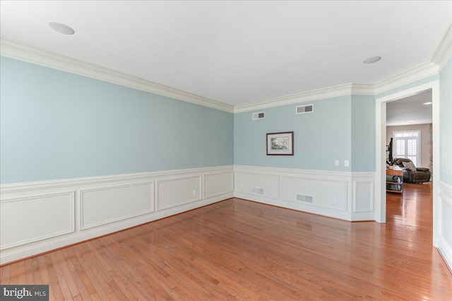 spare room with crown molding and hardwood / wood-style flooring