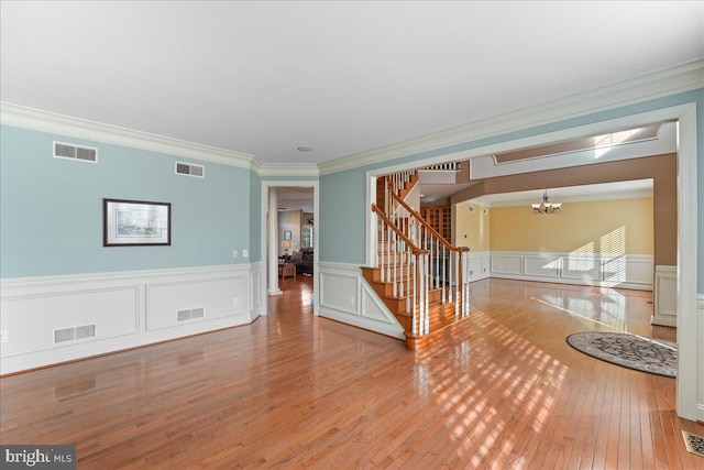 spare room featuring ornamental molding, a chandelier, and hardwood / wood-style flooring