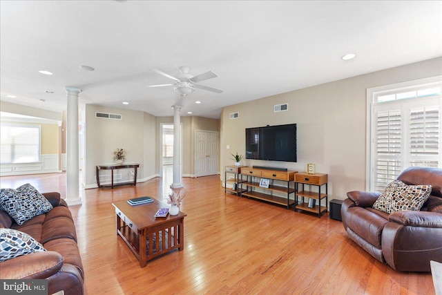 living room with ceiling fan, light hardwood / wood-style flooring, and decorative columns