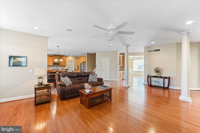 living room with ceiling fan, light hardwood / wood-style flooring, and decorative columns