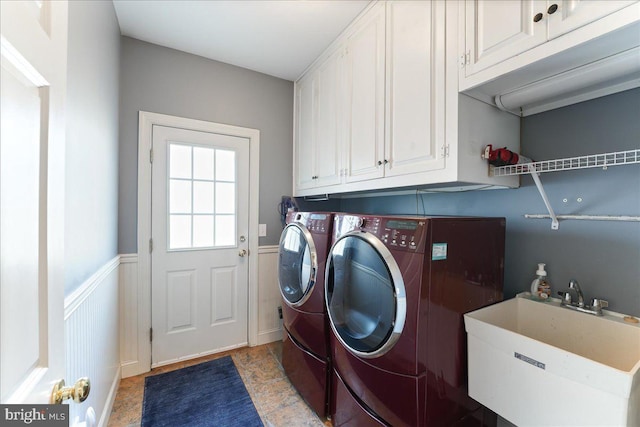 washroom featuring sink, washing machine and clothes dryer, and cabinets