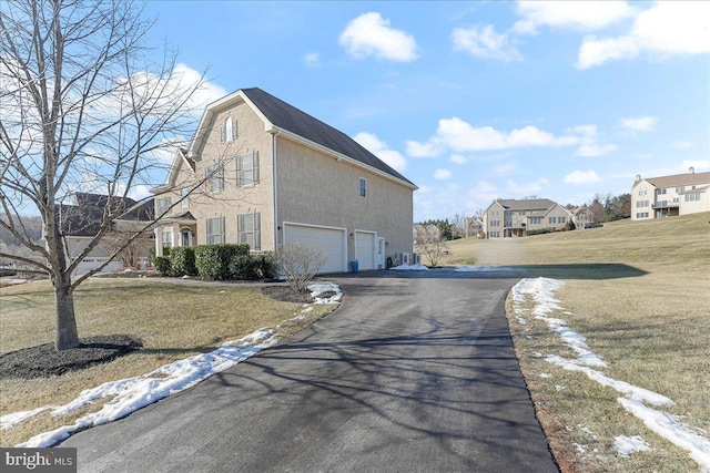 view of property exterior with a yard and a garage