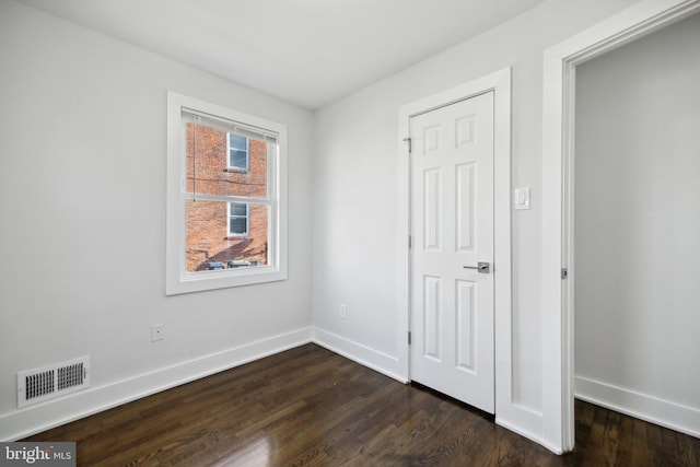 unfurnished bedroom featuring dark hardwood / wood-style floors