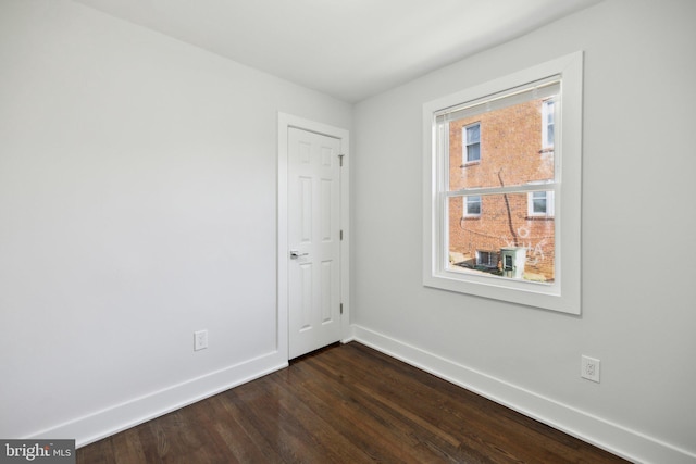 empty room with dark hardwood / wood-style flooring