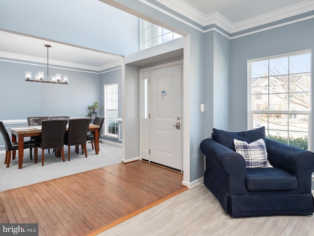 entryway featuring plenty of natural light, ornamental molding, and a chandelier