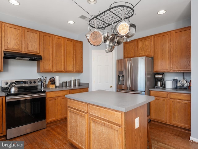 kitchen featuring dark wood-type flooring, appliances with stainless steel finishes, and a kitchen island