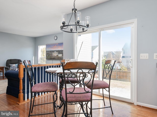 dining area featuring hardwood / wood-style floors and a notable chandelier