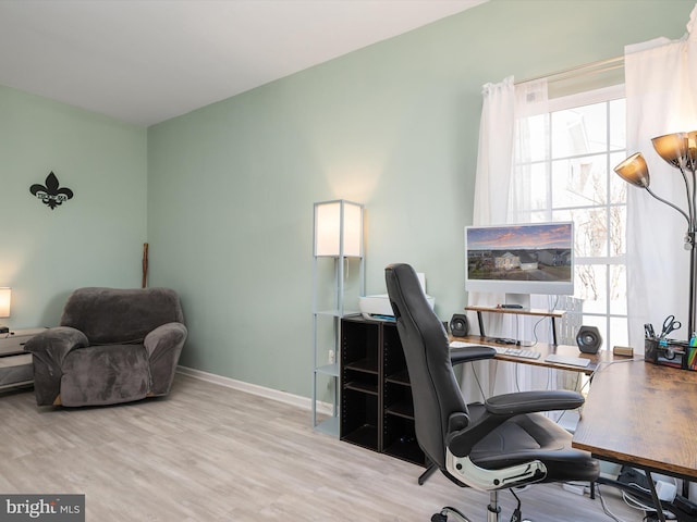 office space with light hardwood / wood-style flooring and a healthy amount of sunlight