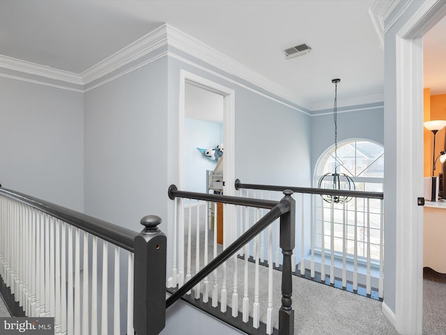 stairs featuring crown molding, a chandelier, and carpet