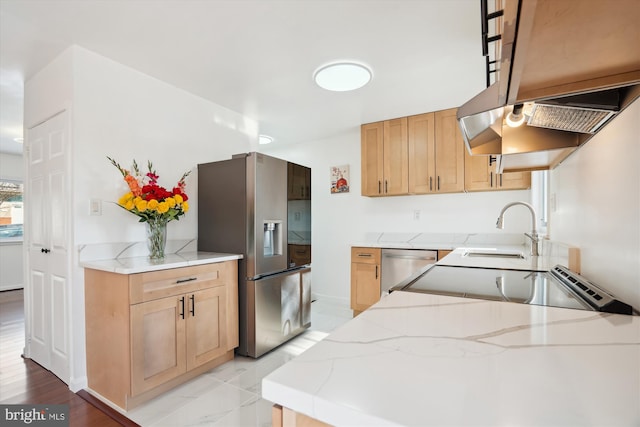 kitchen with light stone counters, sink, light brown cabinets, and appliances with stainless steel finishes