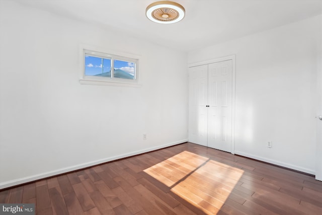 unfurnished bedroom featuring a closet and dark hardwood / wood-style flooring