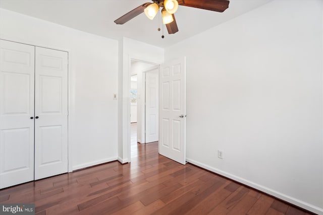 unfurnished bedroom featuring ceiling fan, a closet, and dark hardwood / wood-style flooring