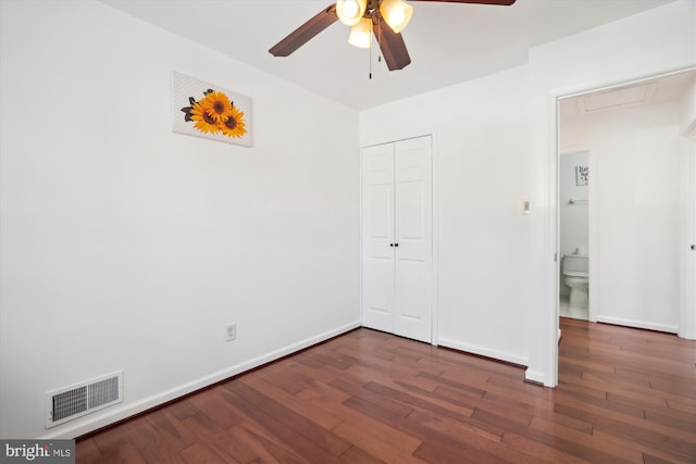 unfurnished bedroom with ceiling fan, a closet, and dark hardwood / wood-style floors