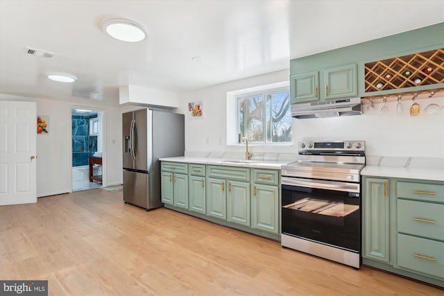 kitchen featuring light hardwood / wood-style floors, sink, appliances with stainless steel finishes, and green cabinets