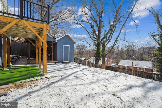 yard layered in snow featuring a storage shed