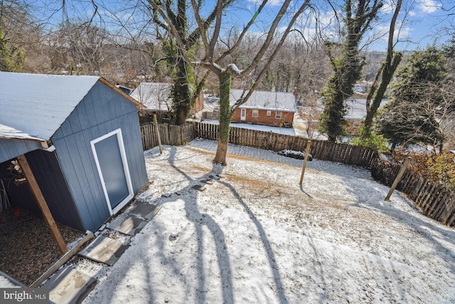 yard layered in snow with a storage shed