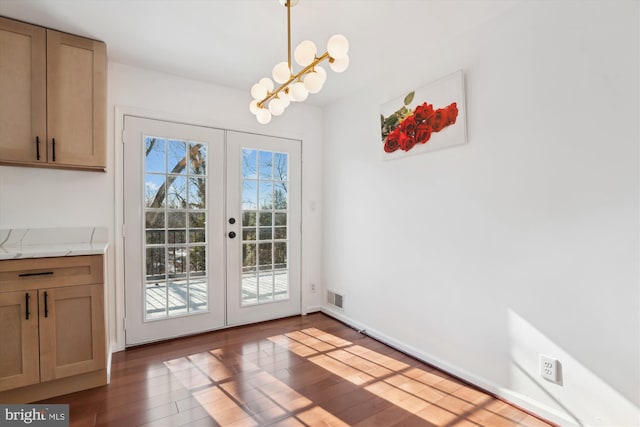 doorway featuring dark wood-type flooring, french doors, and a notable chandelier