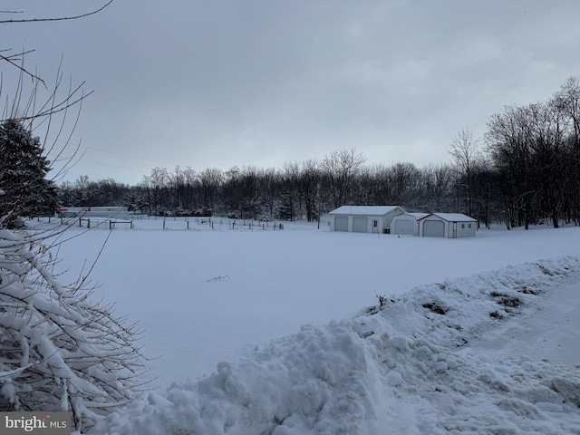 snowy yard featuring a garage