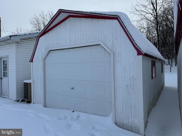 snow covered garage featuring central AC unit