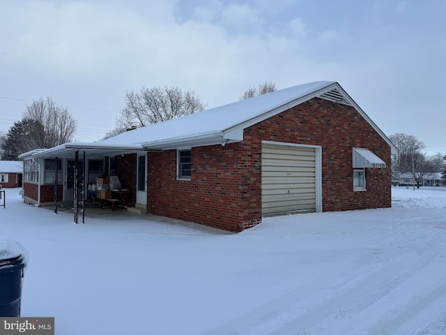 view of snow covered exterior featuring a garage