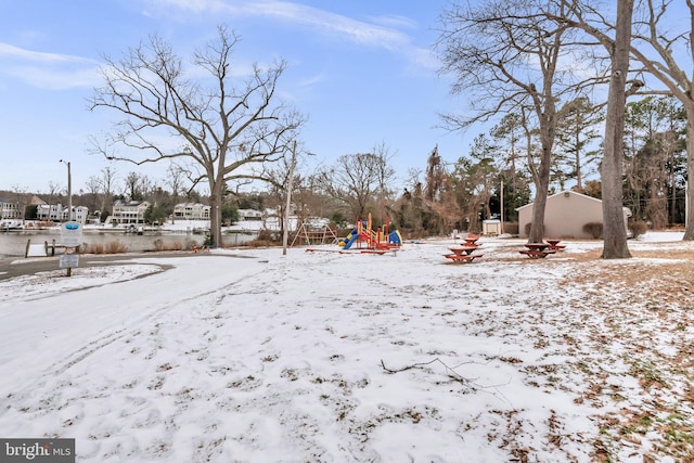 snowy yard featuring a playground