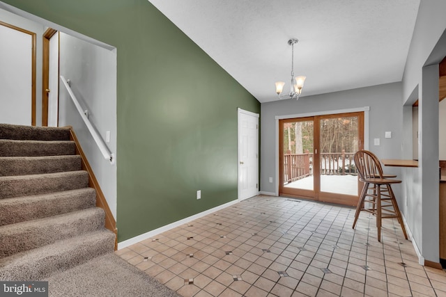 interior space featuring lofted ceiling, light tile patterned floors, french doors, and an inviting chandelier