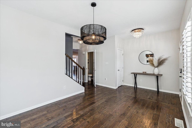 entrance foyer featuring dark hardwood / wood-style floors and an inviting chandelier