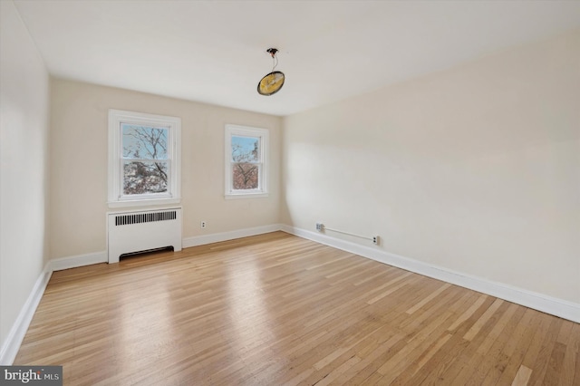 spare room featuring light wood-type flooring and radiator heating unit