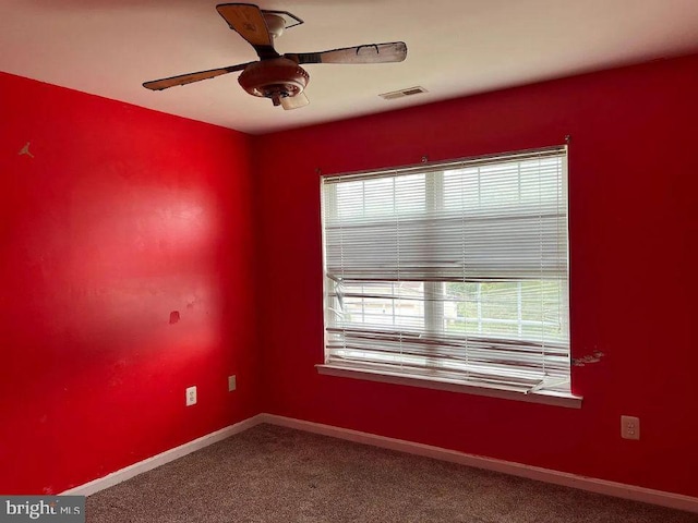 carpeted spare room with ceiling fan