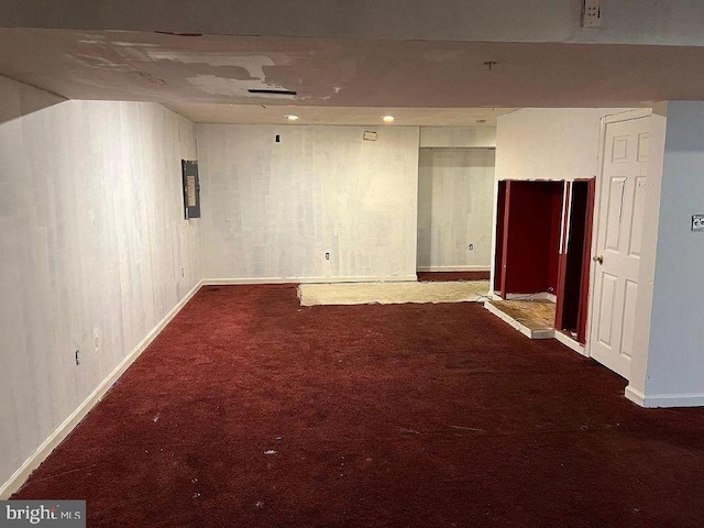 basement featuring dark carpet and electric panel