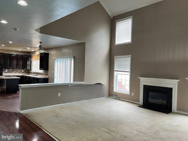 kitchen with sink, backsplash, ornamental molding, ceiling fan, and dark brown cabinets