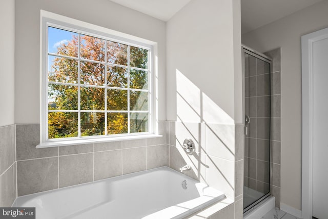 bathroom featuring a healthy amount of sunlight and plus walk in shower