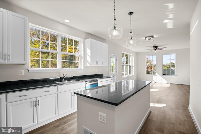 kitchen featuring white cabinetry, dark hardwood / wood-style flooring, sink, and a kitchen island