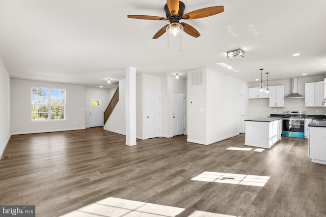 unfurnished living room featuring hardwood / wood-style flooring and ceiling fan