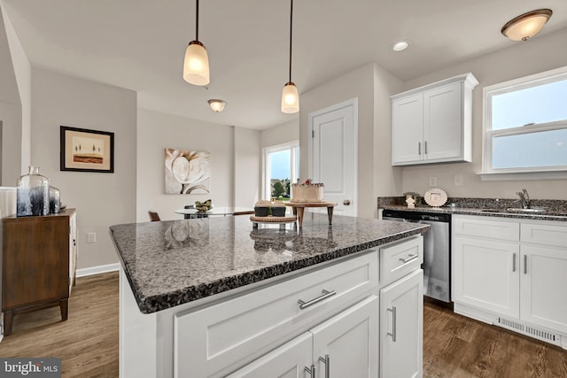 kitchen with white cabinets, dishwasher, a kitchen island, sink, and hanging light fixtures