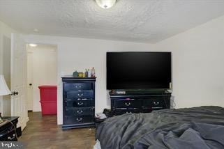 bedroom with dark wood-type flooring and a textured ceiling