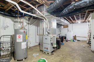 basement with washer / clothes dryer, electric water heater, and heating unit