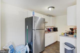 kitchen featuring white cabinetry, dark hardwood / wood-style floors, and stainless steel refrigerator