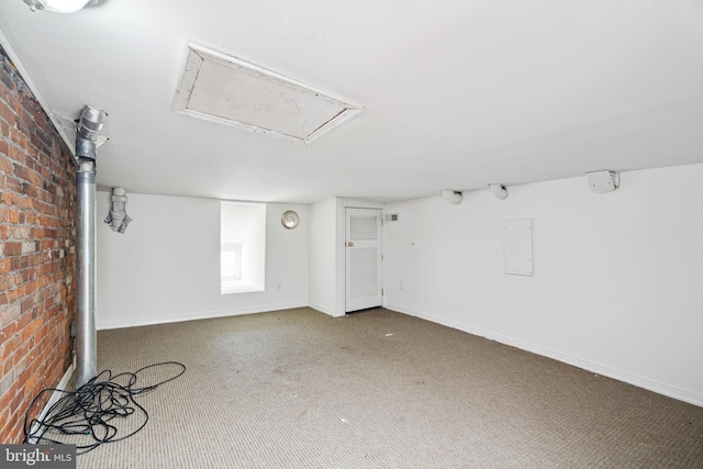 interior space featuring brick wall and carpet flooring