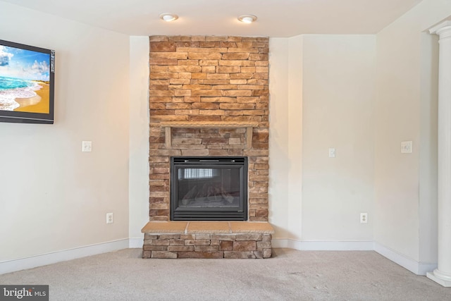 unfurnished living room featuring carpet, a fireplace, and decorative columns