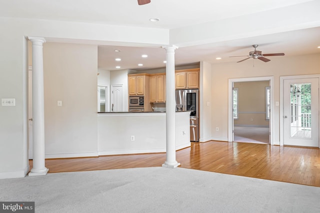 unfurnished living room with light wood-type flooring, ornate columns, and ceiling fan