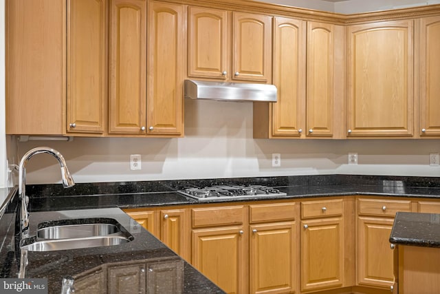 kitchen featuring dark stone counters, sink, and stainless steel gas stovetop