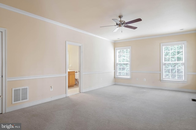 carpeted spare room with ceiling fan and crown molding