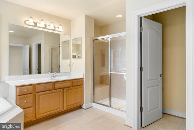 bathroom with a shower with door, vanity, and tile patterned flooring